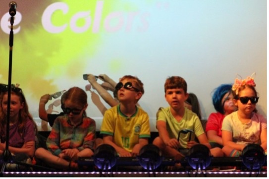 Kinder auf der Bühne während des "Color"-Assemblys